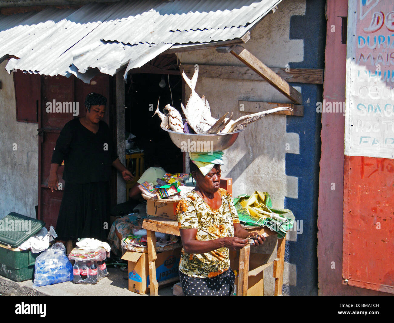 Eine Frau trägt eine Schüssel mit Fisch durch die Cite Soleil Slum in Port au Prince nach dem Erdbeben in Haiti Stockfoto
