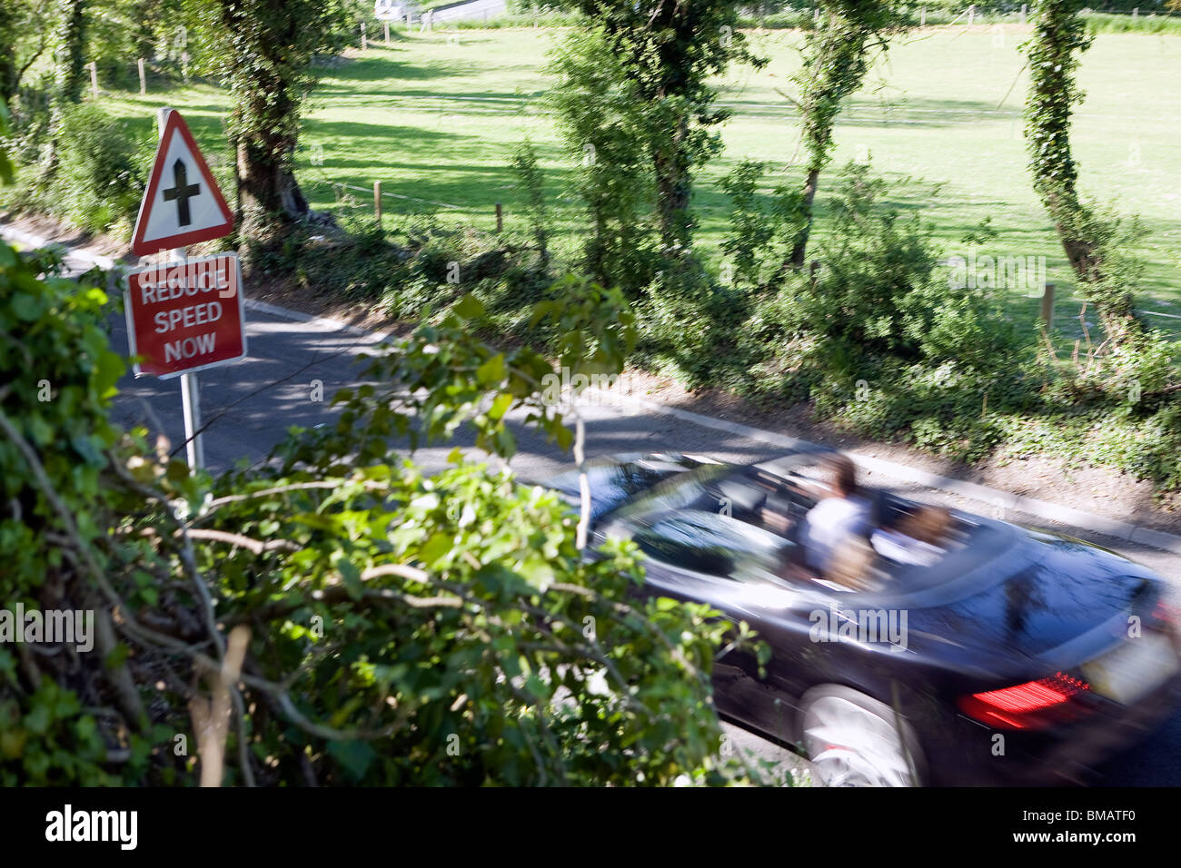 Reduzieren Sie Geschwindigkeit Zeichen und schnelles Auto. Stockfoto