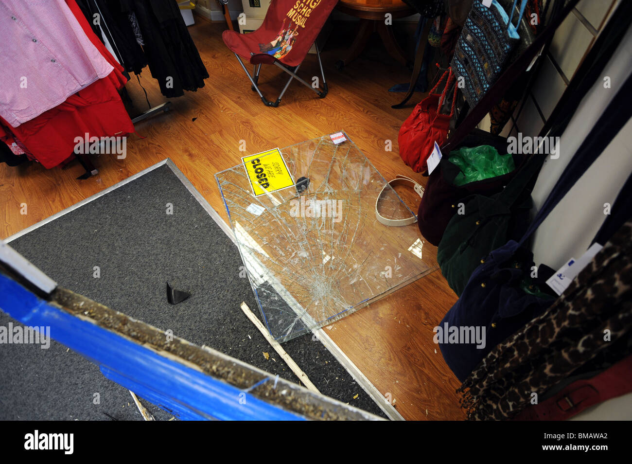 Eine zertrümmerte Fenster liegt auf dem Boden nach einer Pause in einem Charity-Shop in Brighton Stockfoto