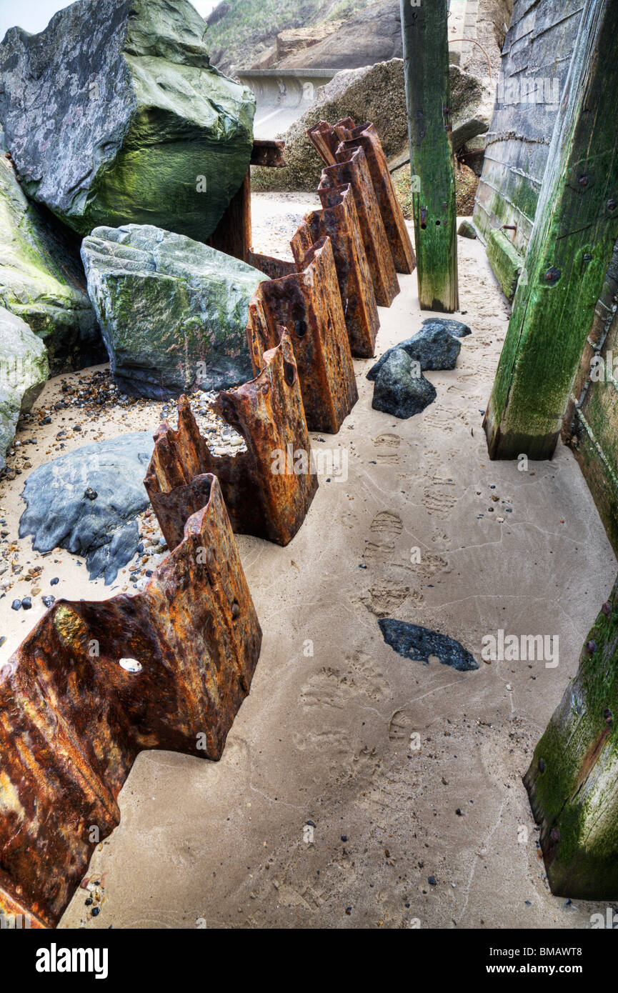 Rostige Schmiedearbeiten und Felsen an einer Küste. Stockfoto