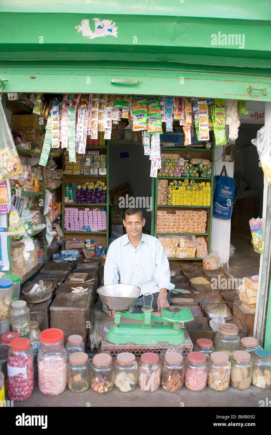 Kleine ländliche Store Ladenbesitzer vor Waage sitzen; Dorf Dilwara; Udaipur; Rajasthan; Indien Stockfoto