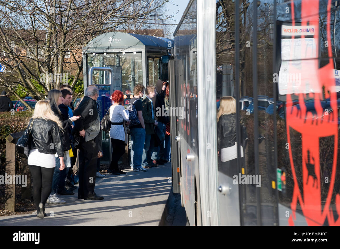 Fahrgäste einsteigen in einen Bus an einer Bushaltestelle in England Stockfoto
