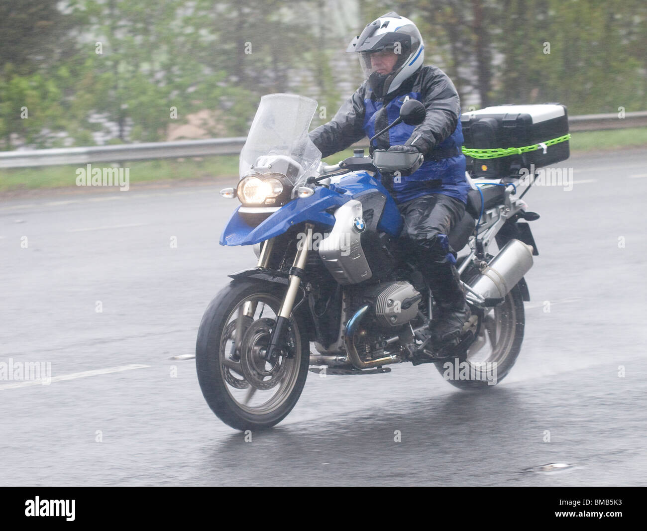 Schlechtem Wetter regen Nebel Spray dunklen Straße touring Motorrad mit einem nassen Motorradfahrer Sommer UK Stockfoto