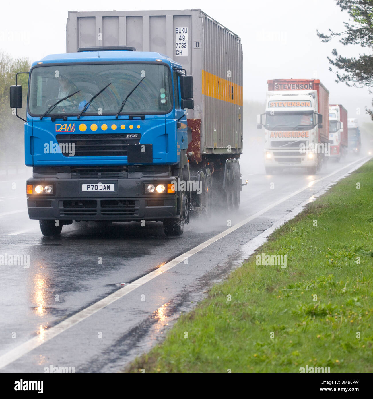 Eine beschäftigt zweispurigen Straße A75 in der Nähe von Dumfries Schottland UK Schlechtwetter regen Nebel Spritzleitung LKW mit Licht Stockfoto