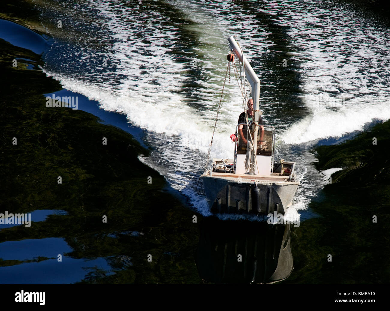 Dory Workboat Beschleunigung mit weißen Wake in Vancouver Island, Britisch-Kolumbien Stockfoto