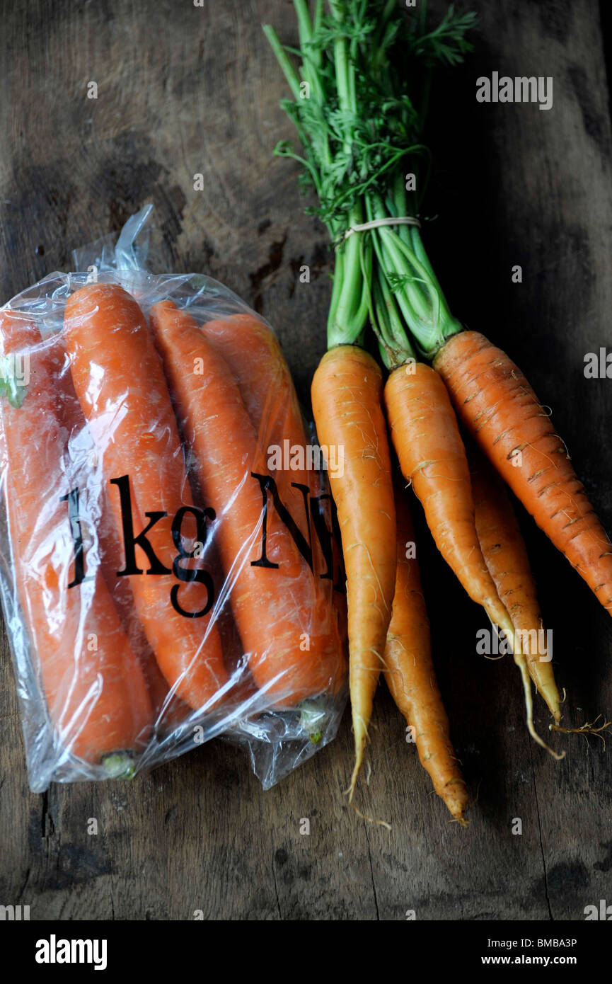 Eine Plastiktüte Supermarkt Karotten neben Bio-Markt Karotten. Stockfoto