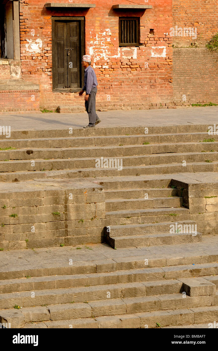 nepalesische Greis zu Fuß entlang der Aussichtspunkt mit Blick auf die Feuerbestattung Ghats am Pashupatinath Hindu Tempel, Kathmandu, nepal Stockfoto