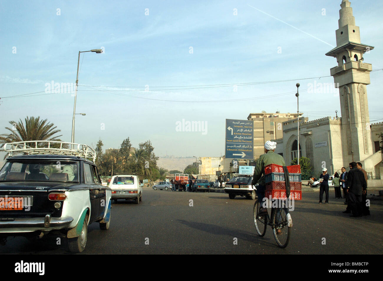 Ein ägyptischer Radfahrer navigiert Autoverkehr und Fußgänger auf der Straße in der Stadt Kairo, Ägypten.. Stockfoto