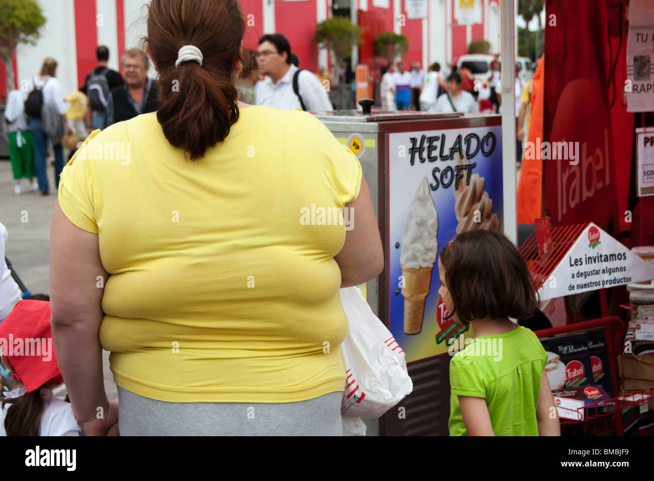 Übergewichtige Frau in Warteschlange am Eis-stand in Spanien Stockfoto