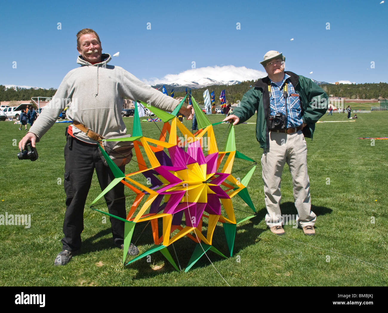 Eine Reihe von lokalen Fotografen zeigen einen bunten Drachen vor Sierra Blanca auf das jährliche Drachenfest in Ruidoso, NM. Stockfoto