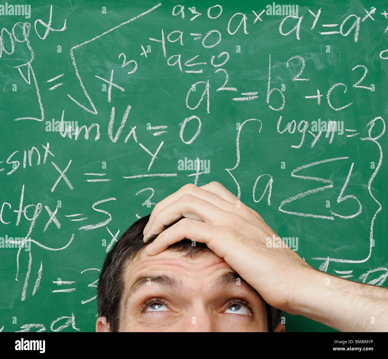 Verwirrten Mann vor Mathe-Formel, die auf einer Tafel geschrieben Stockfoto