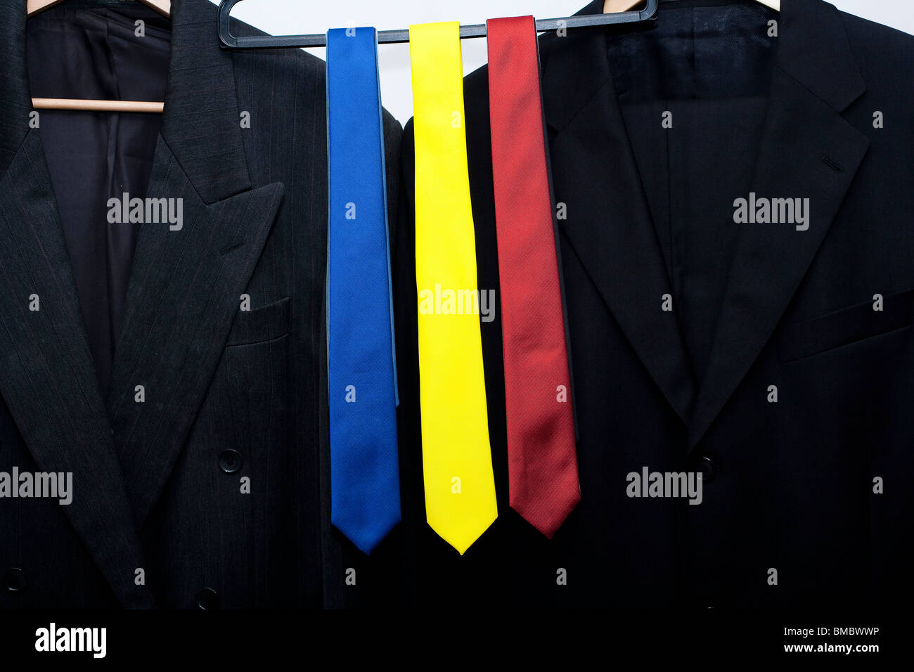 rote, blaue und gelbe Krawatten auf einer Schiene in einem Geschäft. als nächstes passen Sie Jacken. Metapher für die britische allgemeine Wahl 2010 Stockfoto