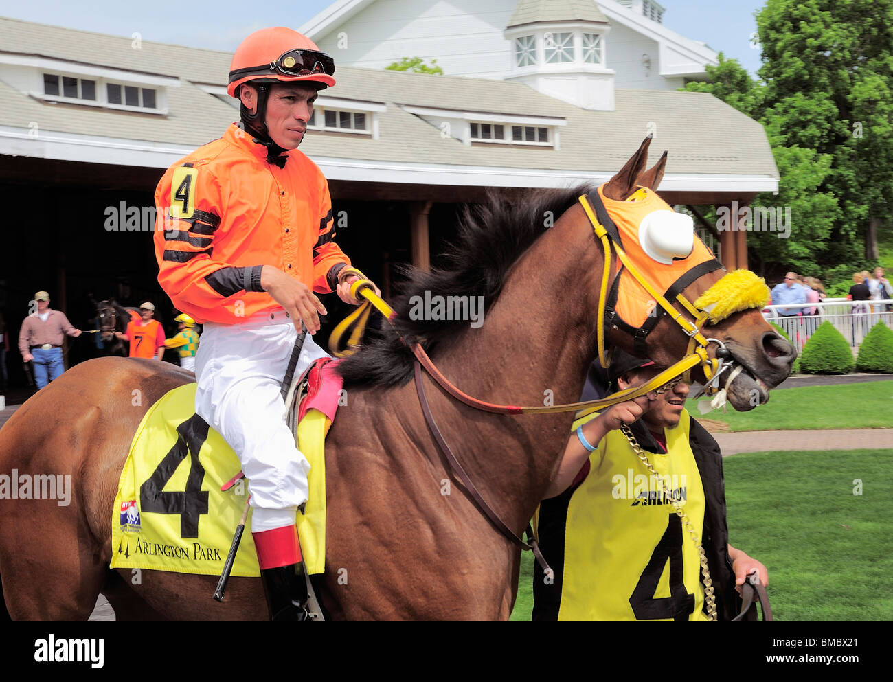 Nummer 4 Pferd und bunten Jockey durch Fahrerlager geführt. Stockfoto