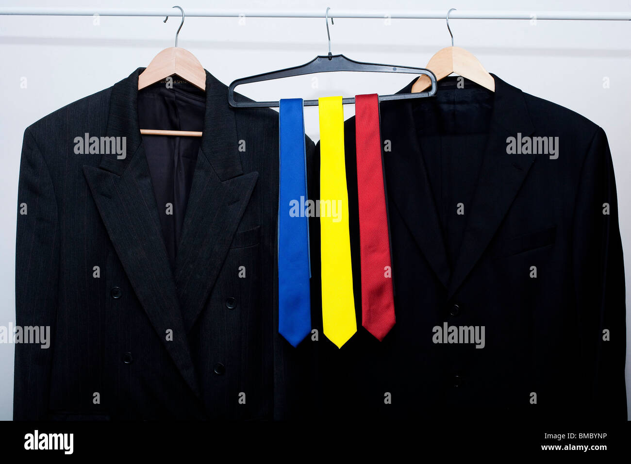 rote, blaue und gelbe Krawatten auf einer Schiene in einem Geschäft. als nächstes passen Sie Jacken. Metapher für die britische allgemeine Wahl 2010 Stockfoto