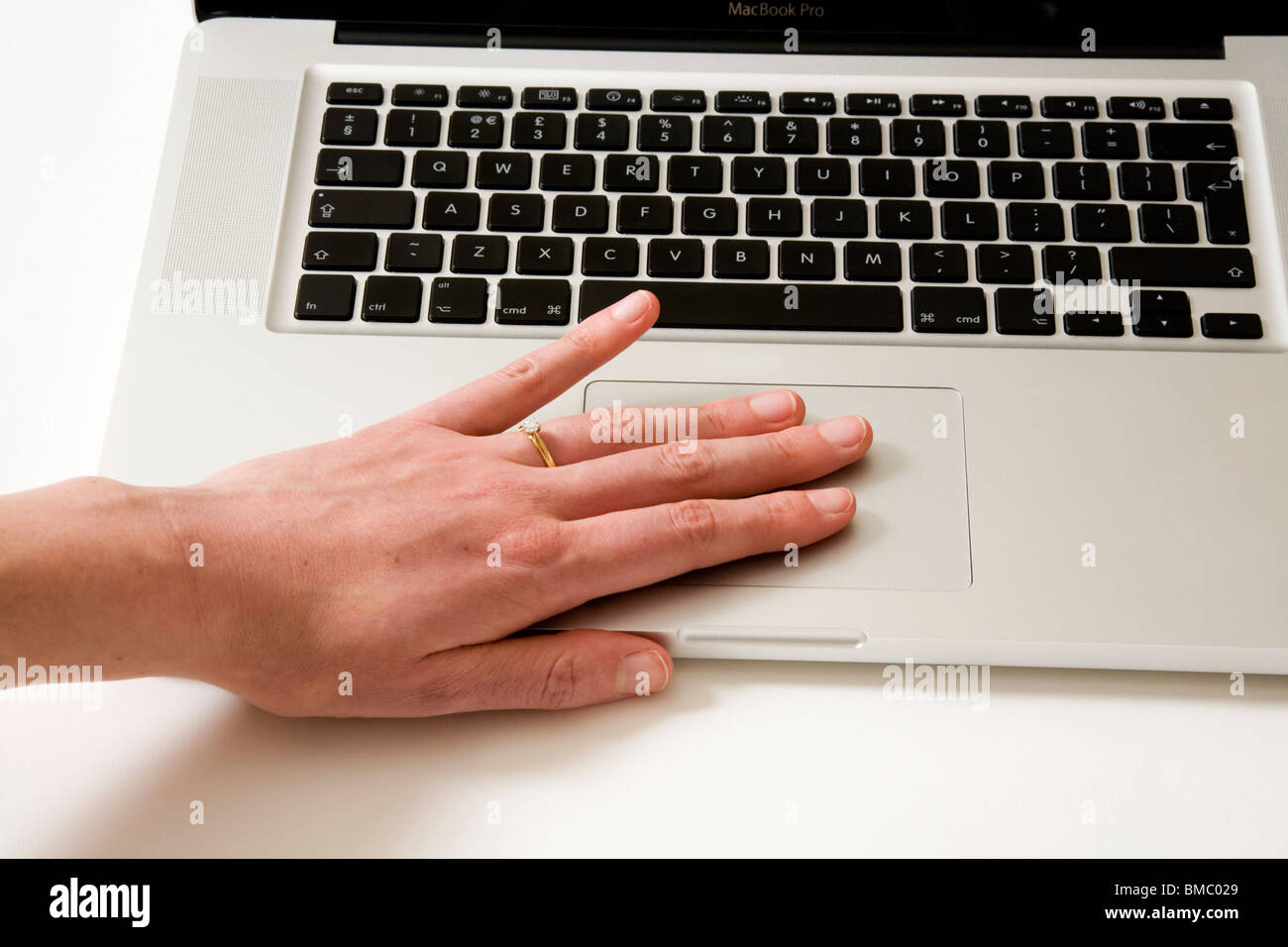 Finger bewegen sich über ein Apple Macbook Pro iBook und scrollen Trackpad / Trackpad auf einem alten Apple Laptop / Laptop Computer Stockfoto