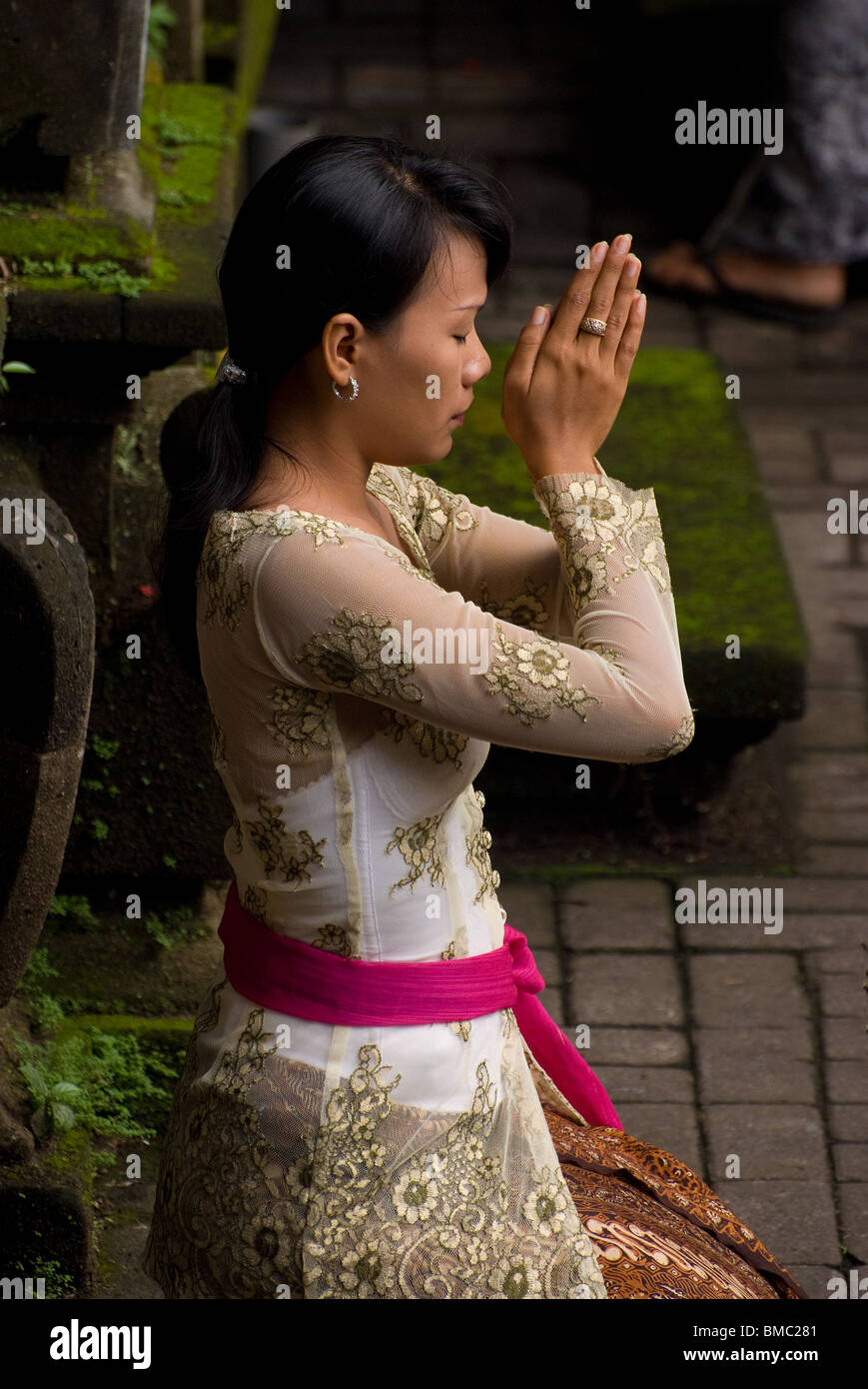 Eine Frau in Bali, Indonesien, kommt zum Ubud Markt Tempel ihren hinduistischen Glauben an den heiligen Tag des Galungan üben. Stockfoto Eine Frau in Bali, Indonesien, kommt zum Ubud Markt Tempel ihren hinduistischen Glauben an den heiligen Tag des Galungan üben. Stockfoto