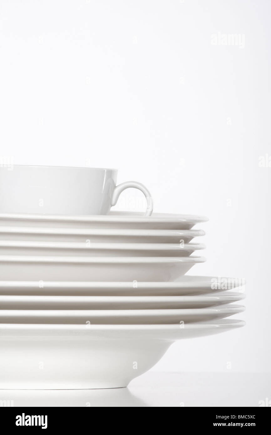 Studioaufnahme von einem Stapel von weißen Platten und weißen Tasse isoliert auf weiss Stockfoto