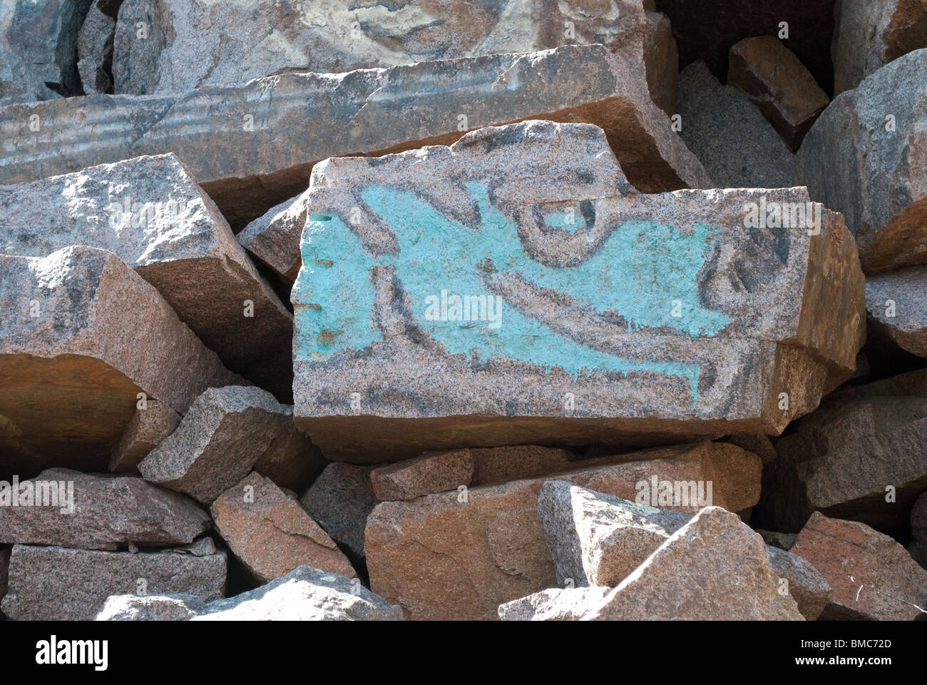 Graffiti auf großen Steinen blau lackiert Stockfoto