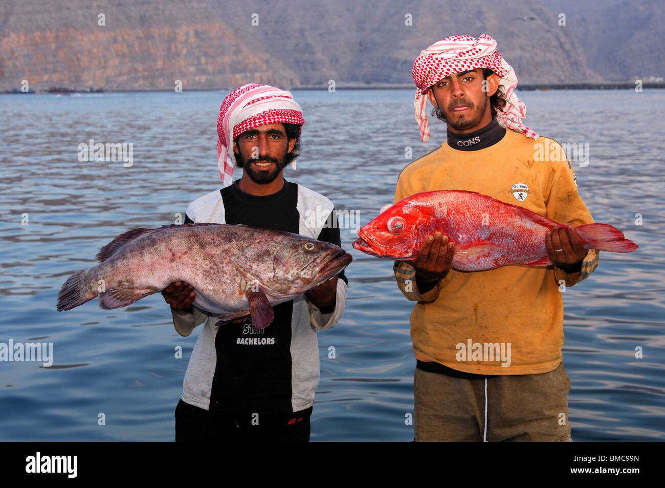 Zwei lokale omanischen Fischer präsentieren stolz ihren Fang, Musandam, Sultanat von Oman Stockfoto