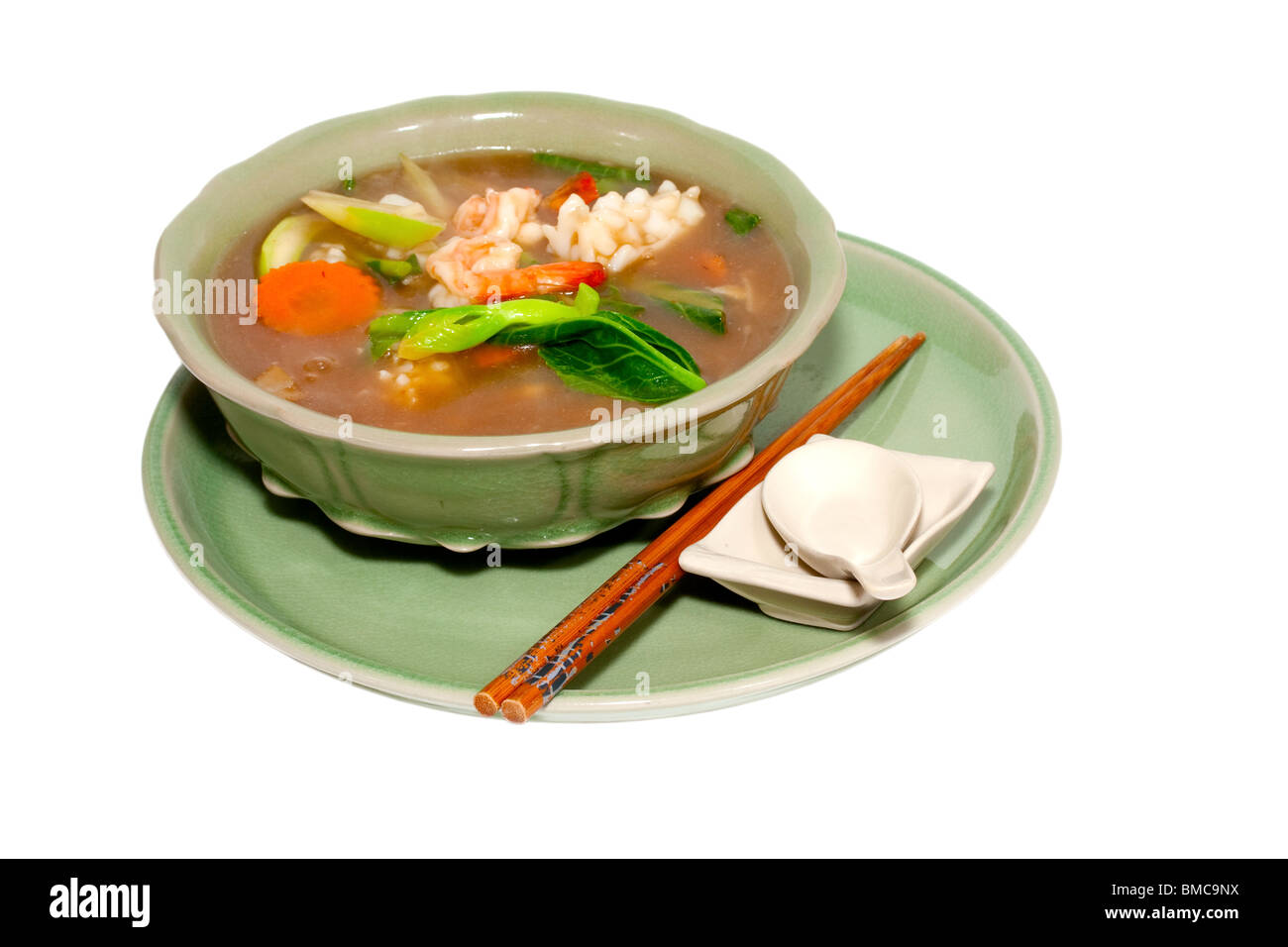 Thai Meeresfrüchte Gericht mit Stäbchen und traditionelle Suppenlöffel ausgeschnitten auf weißem Grund und Oberfläche Stockfoto