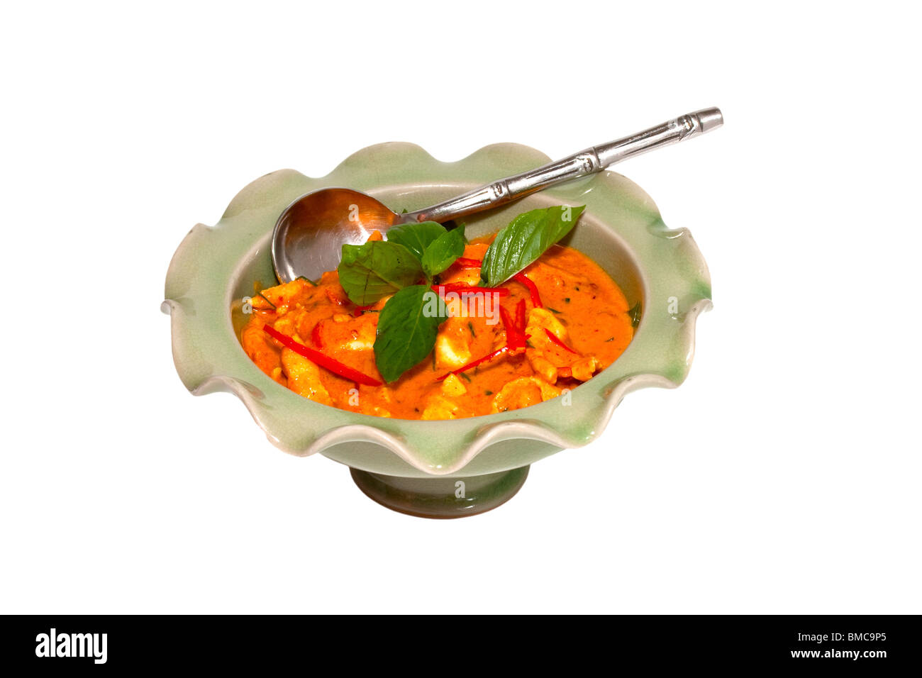 Thai rotes Curry mit Huhn und roten Chilischoten ausgeschnitten auf weißem Grund und Oberfläche Stockfoto