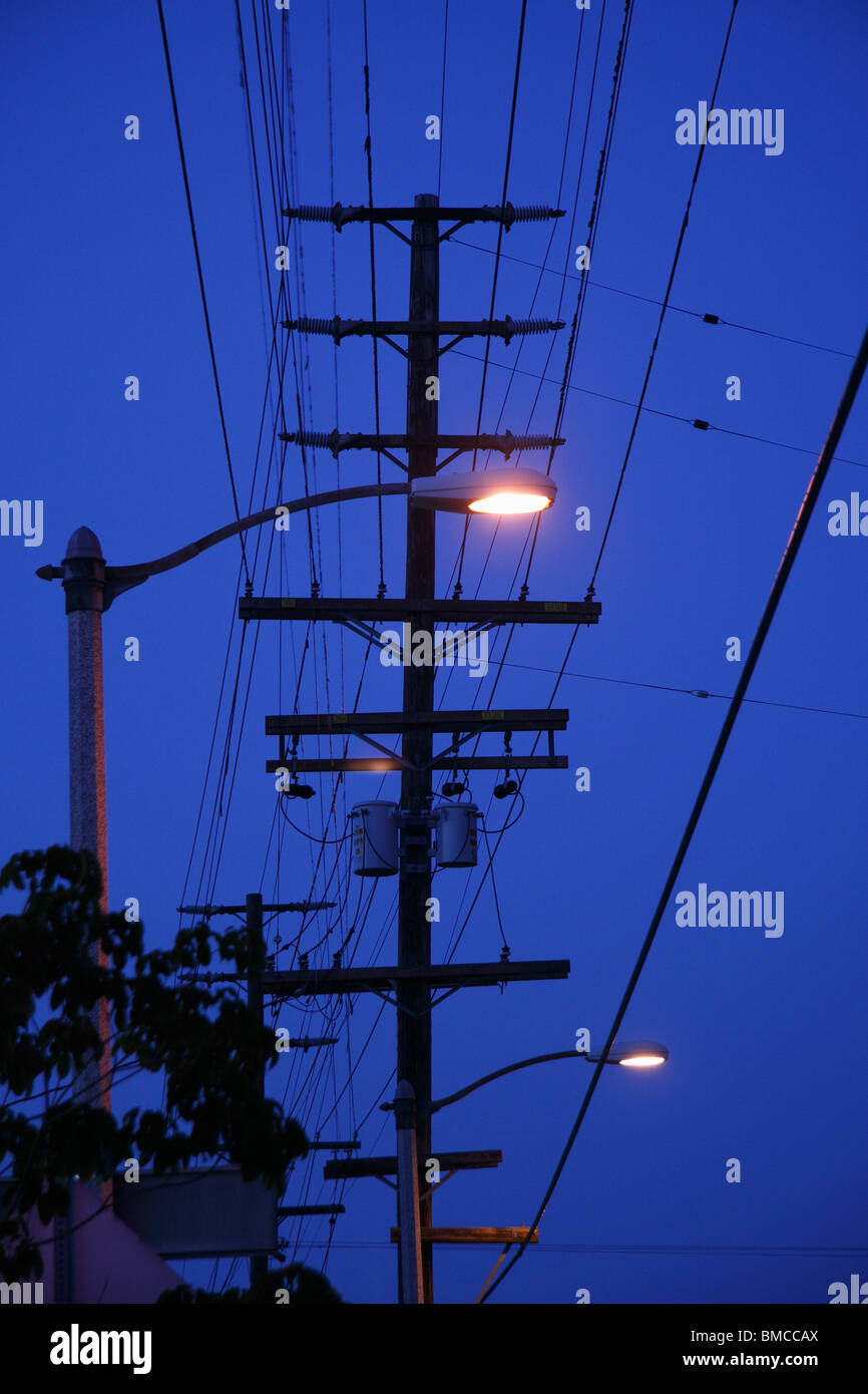 Telefonmasten, Drähte & Straßenleuchten mit Dämmerung Himmel Stockfoto
