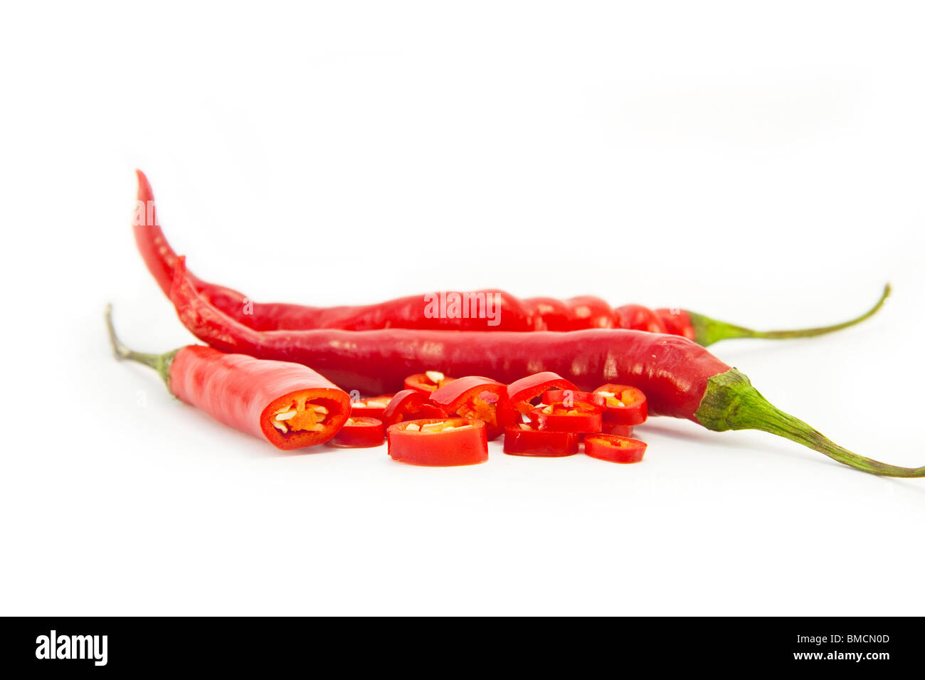 In Scheiben geschnittene rote Chilischoten auf weiß Stockfoto