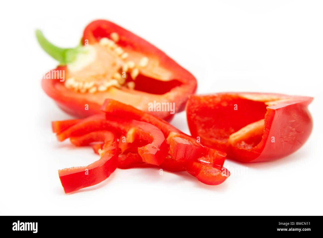 In Scheiben geschnittene rote Paprika (im Vordergrund) Stockfoto