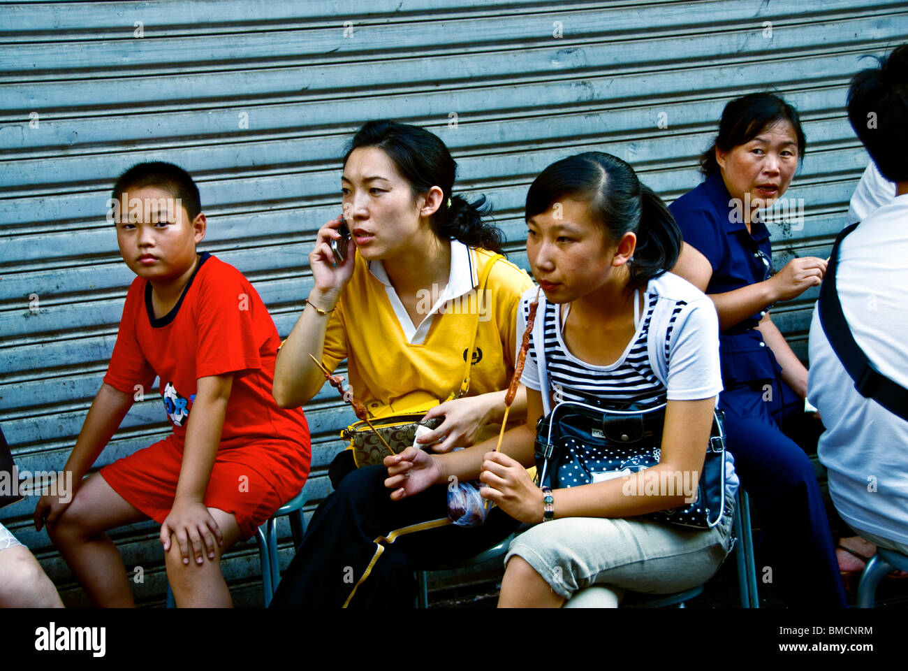 Peking, China, chinesische Familien Essen Fast Food in, Gasse hinter der chinesischen Stadtstraße „Wangfushing Street“ Stockfoto