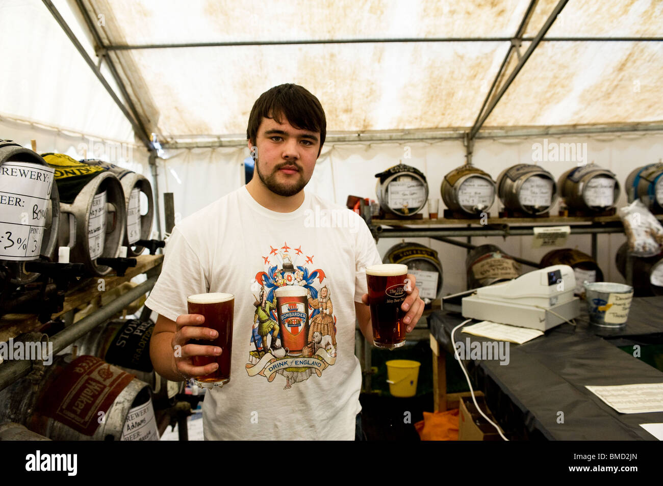 Eine Bar Arbeitnehmer halten zwei Pints Ale am Hoop Beer Festival in Essex. Foto von Gordon Scammell Stockfoto