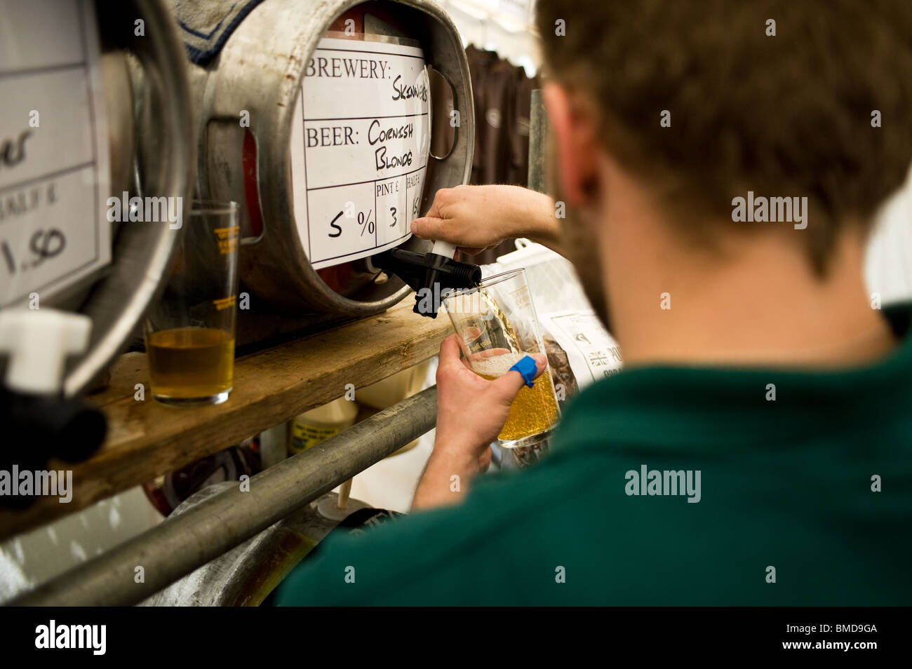 Ein Barangestellter goss beim Hoop Beer Festival in Essex ein Pint echtes Ale. Stockfoto