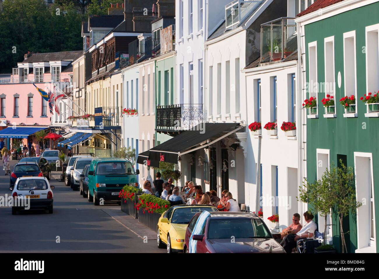 Touristen sitzen außerhalb Restaurants und Bars, Hafen von Gorey, Jersey, Kanalinseln, Großbritannien Stockfoto