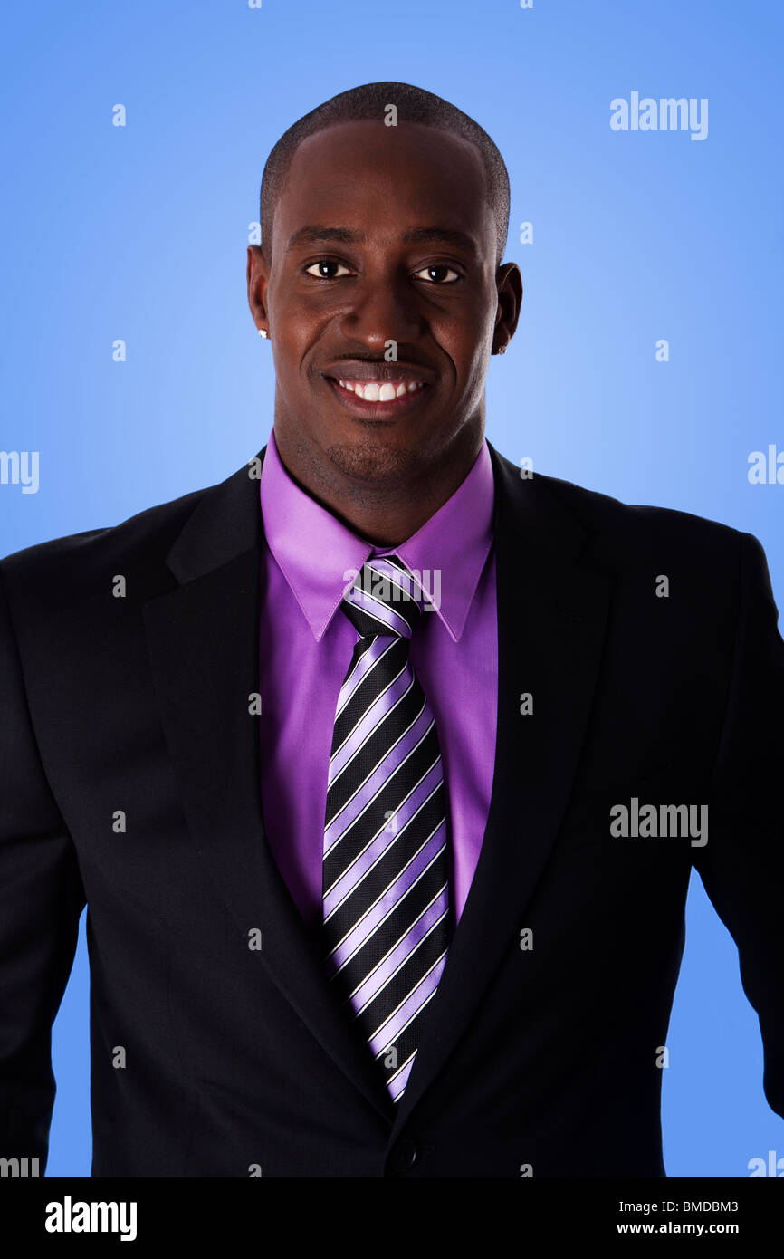 Gut aussehend glücklich African American corporate Business-Mann lächelnd, schwarzen Anzug mit lila Hemd und gestreifter Krawatte. Stockfoto