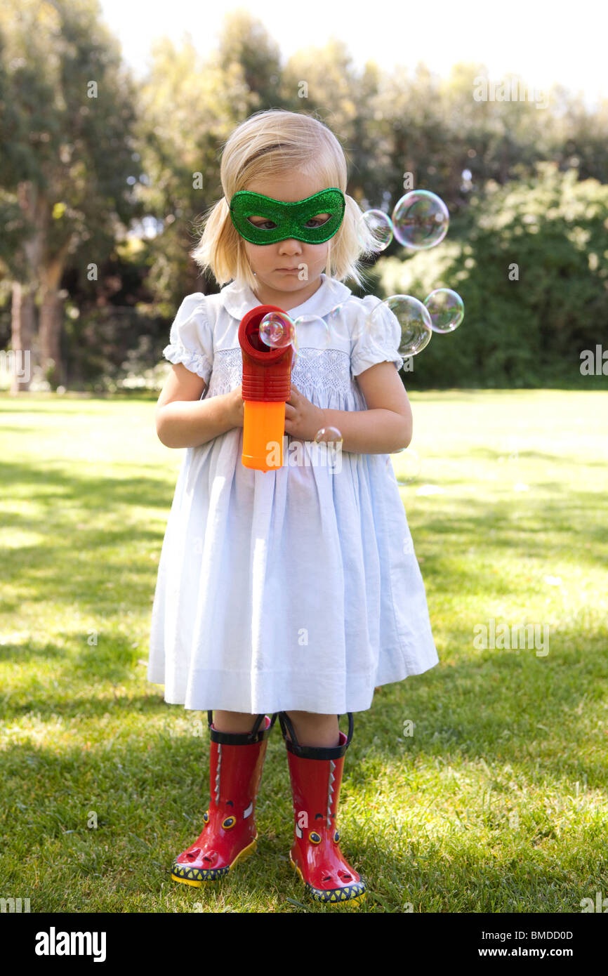 Junges Mädchen mit Bubble Gun in Maske Stockfoto