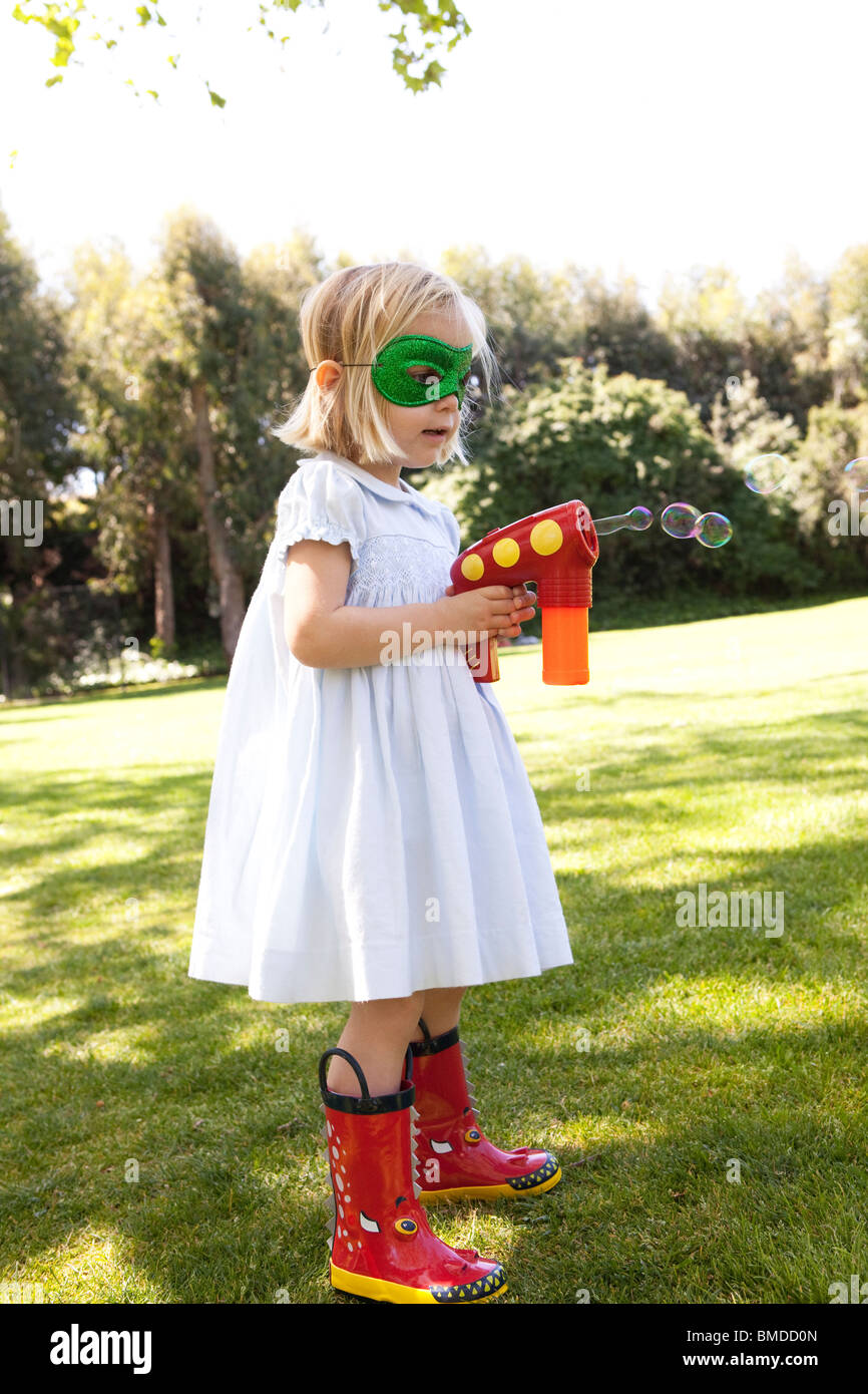 Junges Mädchen mit Bubble Gun in Maske Stockfoto
