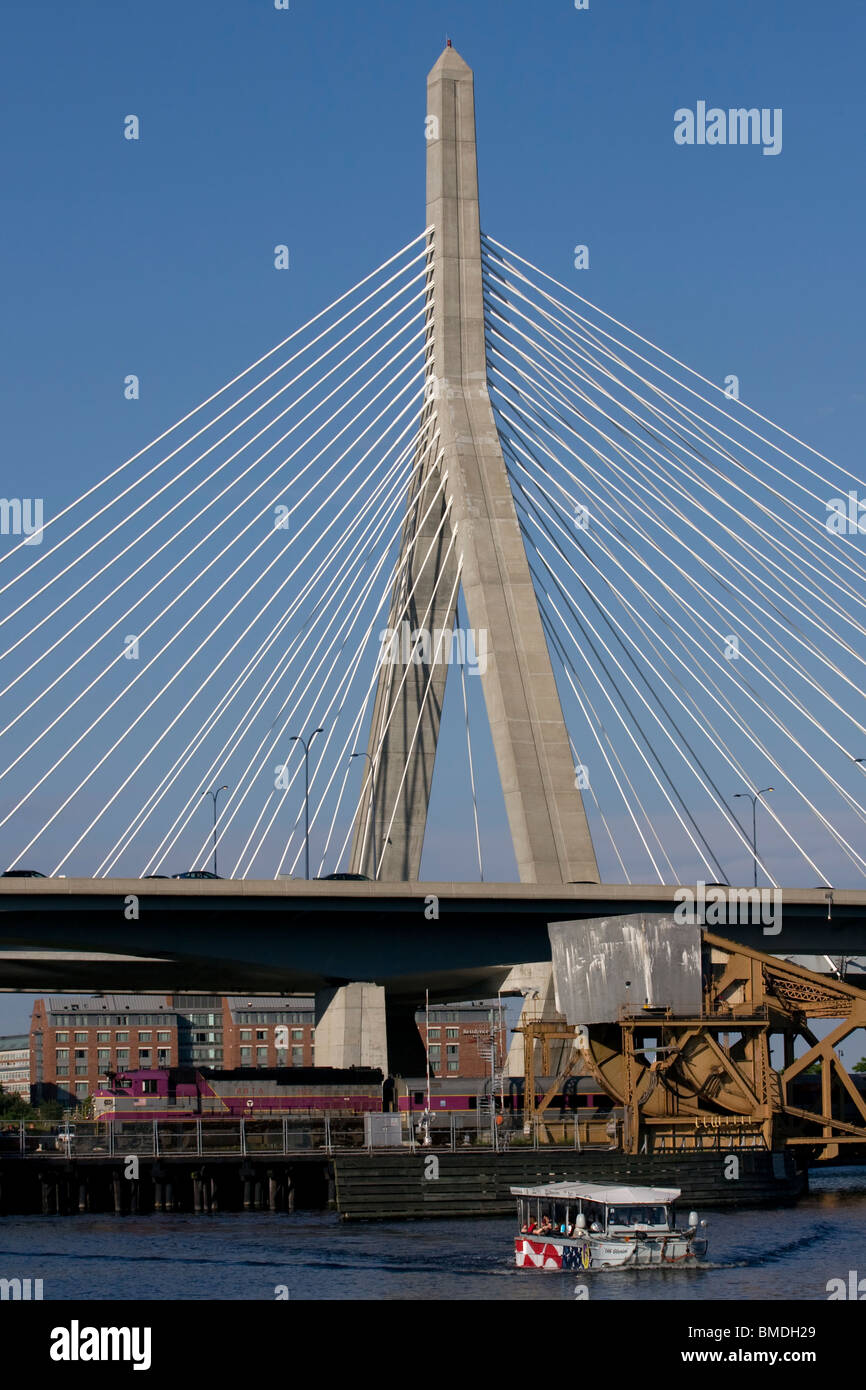Leonard P. Zakim Brücke mit Commuter Rail Train #1129 unter und Ente Boot "Alte Gloria" in Charles River. Stockfoto