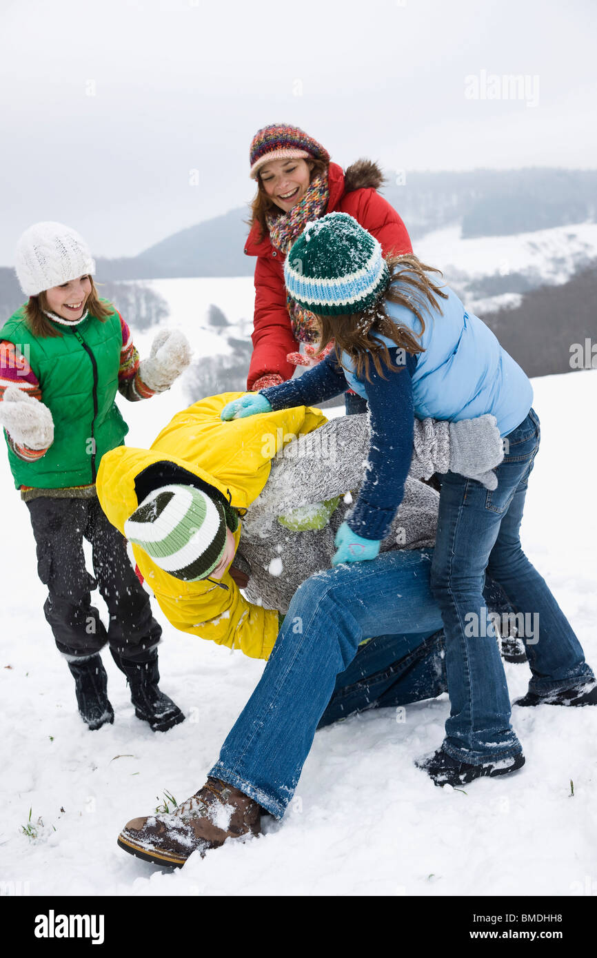 Familie draußen im Schnee spielen Stockfoto