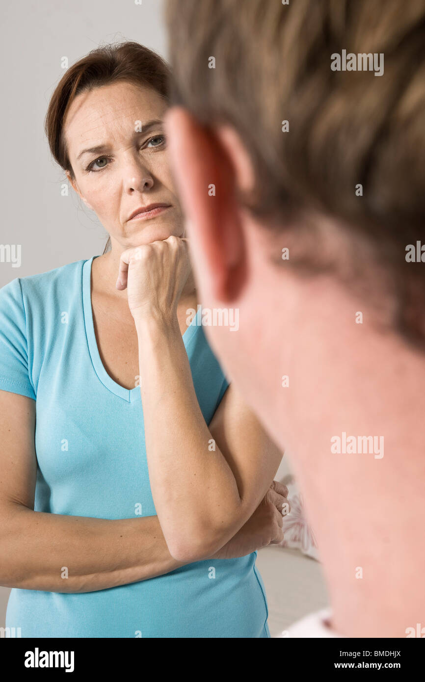 Frau mit der Hand unter Kinn Blick auf Menschen Stockfoto