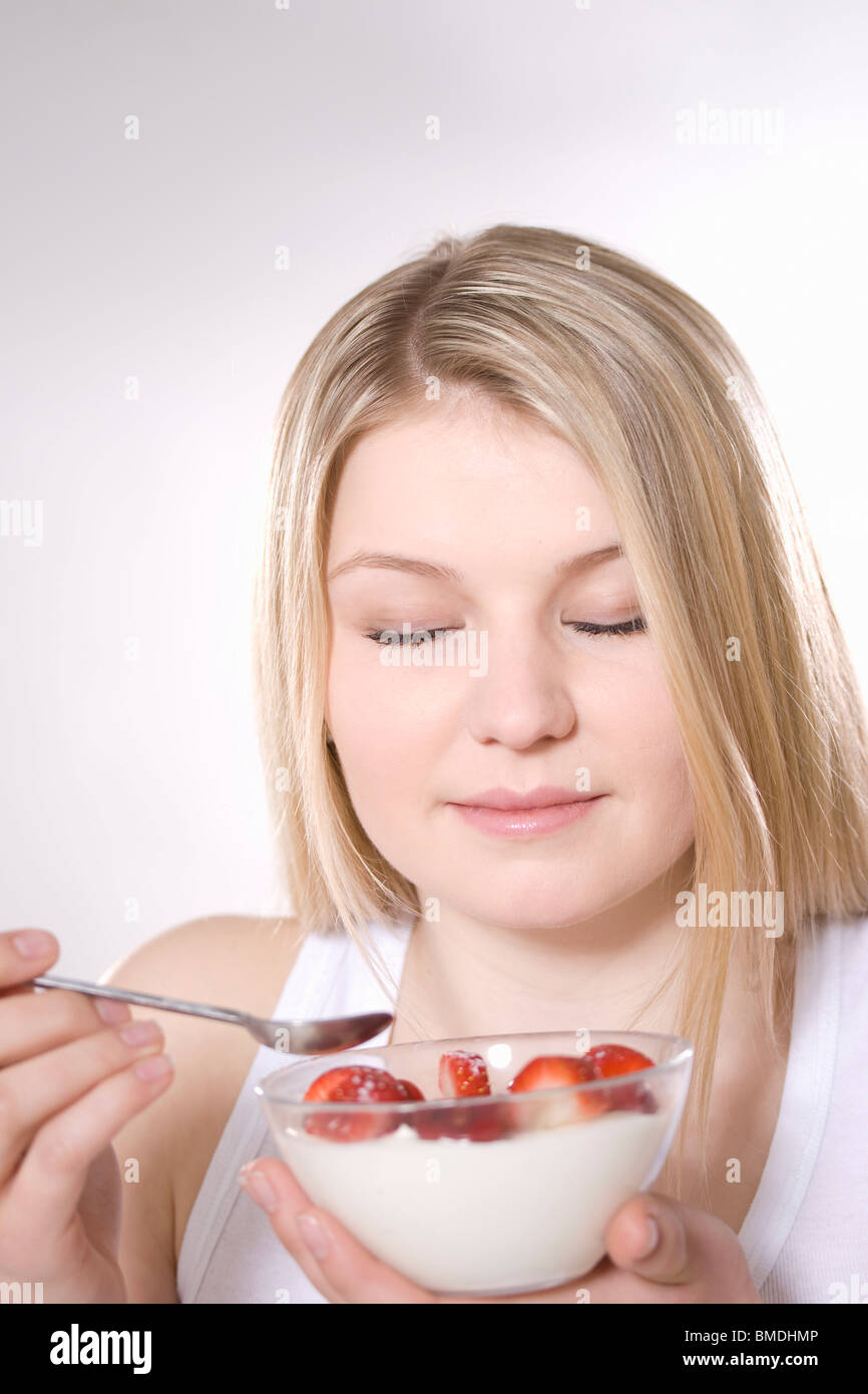 Frau mit Schale mit Erdbeeren und Sahne Stockfoto