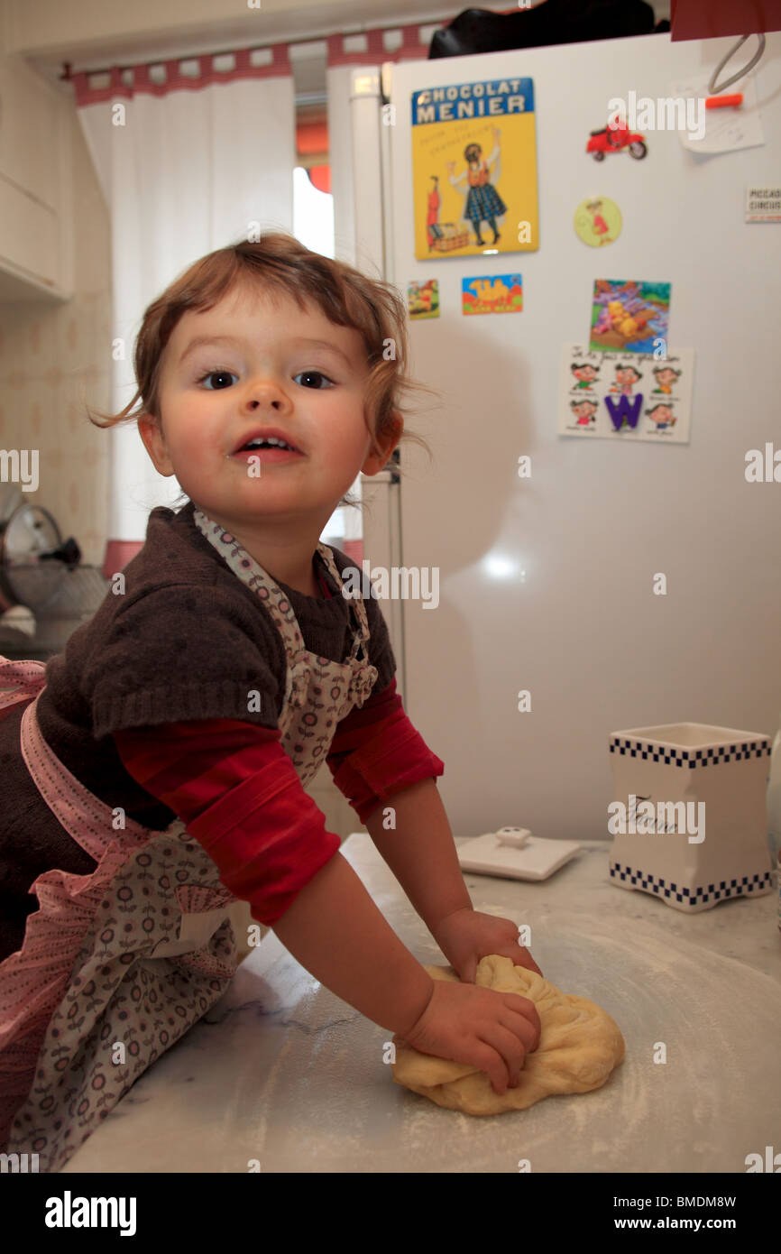 24 Monate altes Mädchen Kneten von Teig für Pizza in der Küche Stockfoto