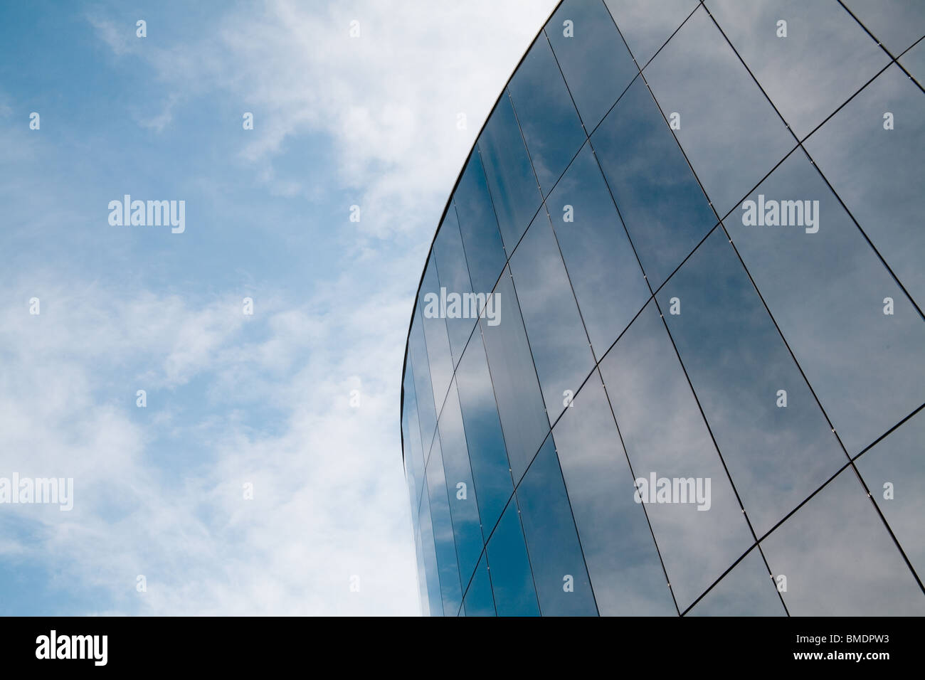 Moderne Runde Gebäude spiegelt den Himmel und Wolken. Stockfoto