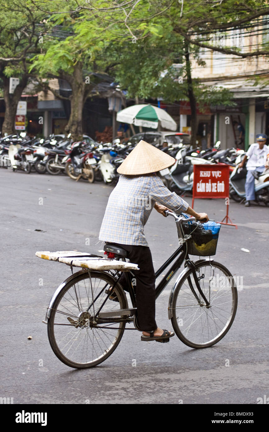 Frau Rad Fahrrad durch die Straßen von Vietnam Stockfoto