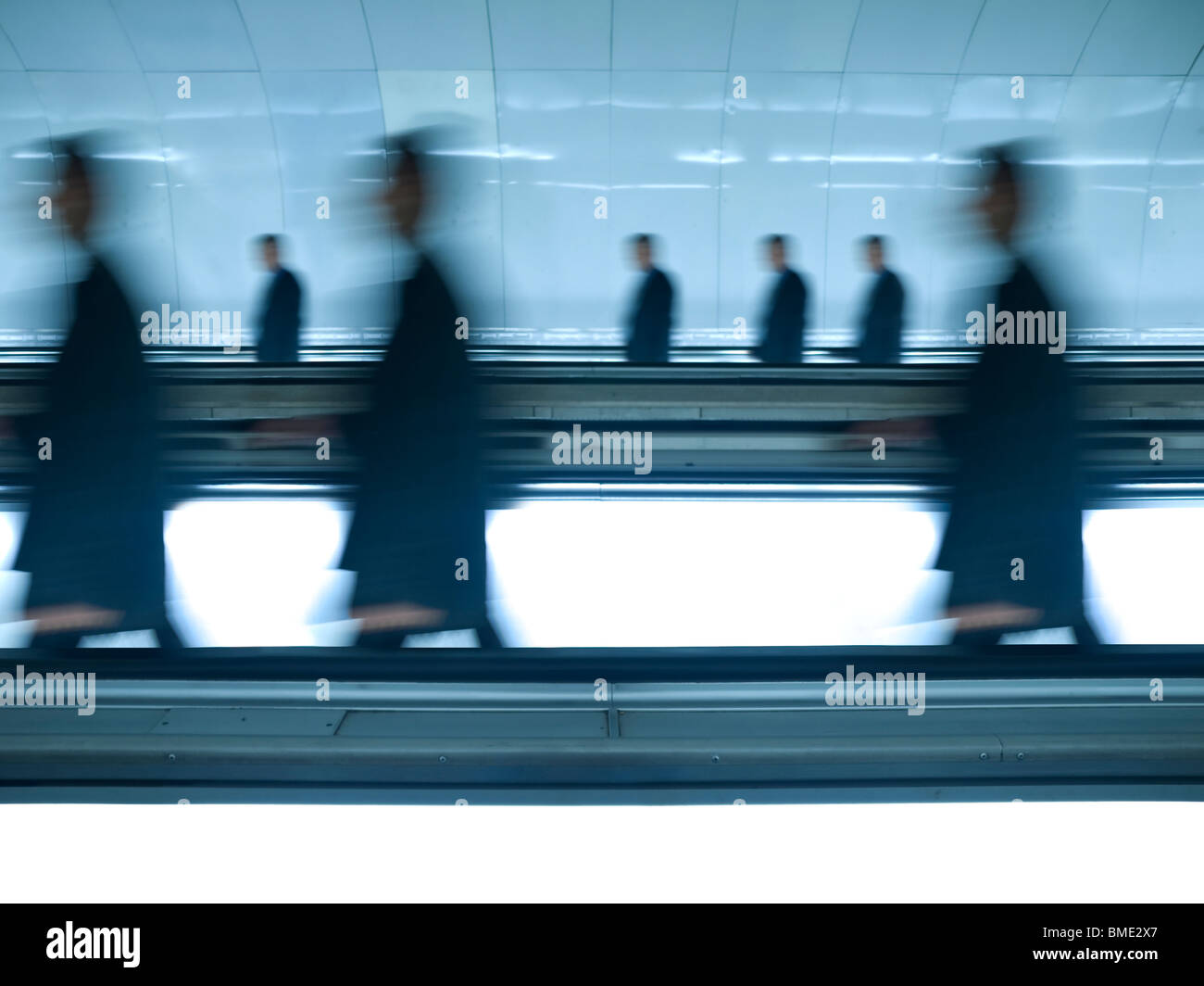 Ähnlich wie Menschen zu Fuß auf die gleiche Richtung durch einen glänzenden Tunnel. Bewegungsunschärfe. Stockfoto