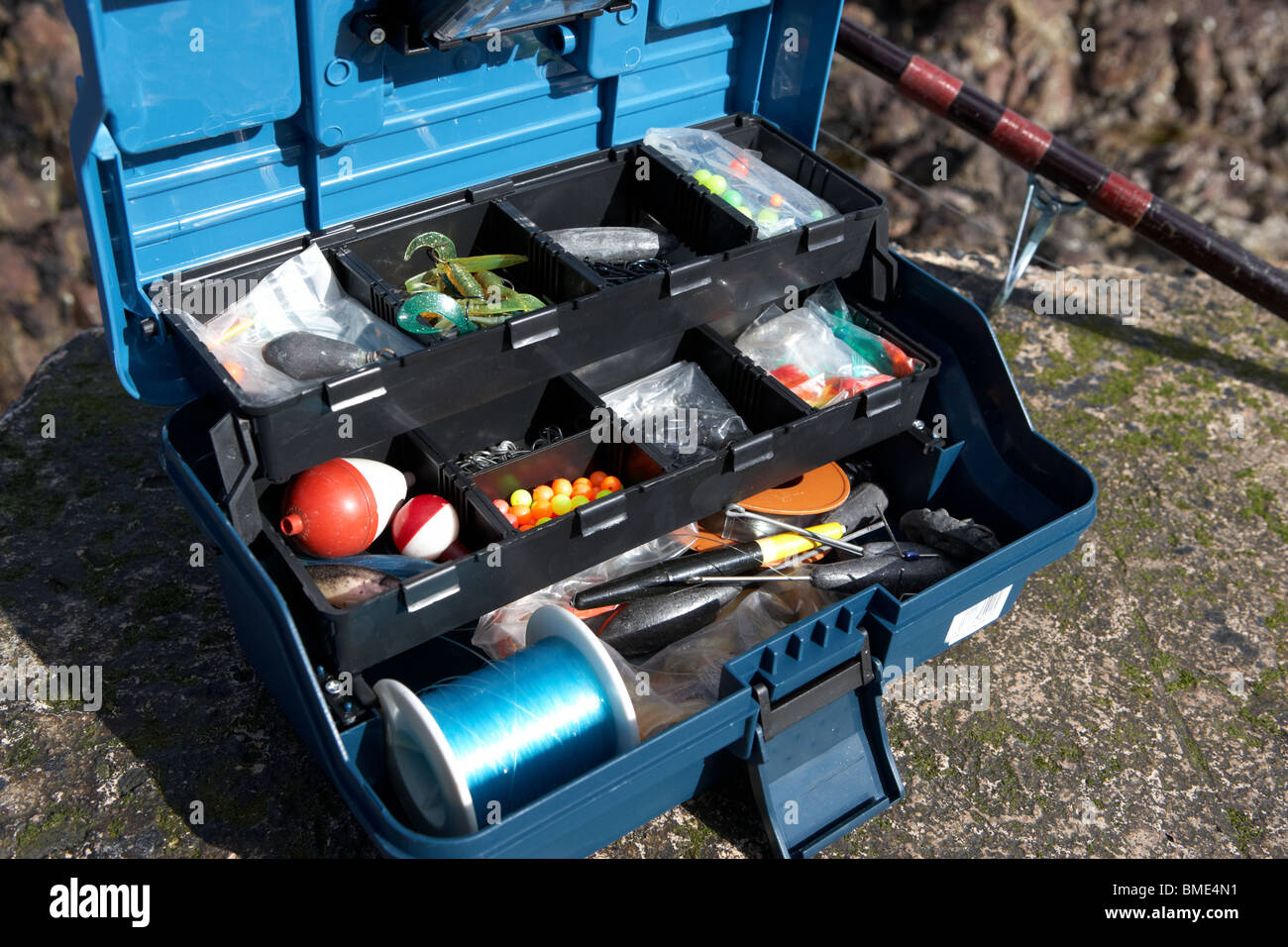 Fishing Tackle Box gefüllt mit Hochseefischen Ausrüstung und Rod uk Stockfoto