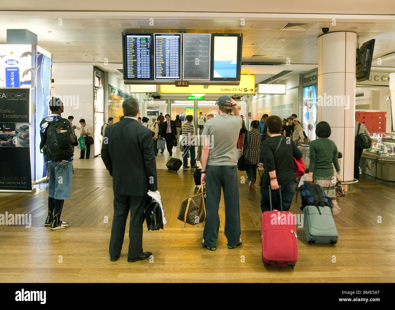 Passagiere warten auf ihren Flug, Terminal 3, Flughafen Heathrow London UK Stockfoto