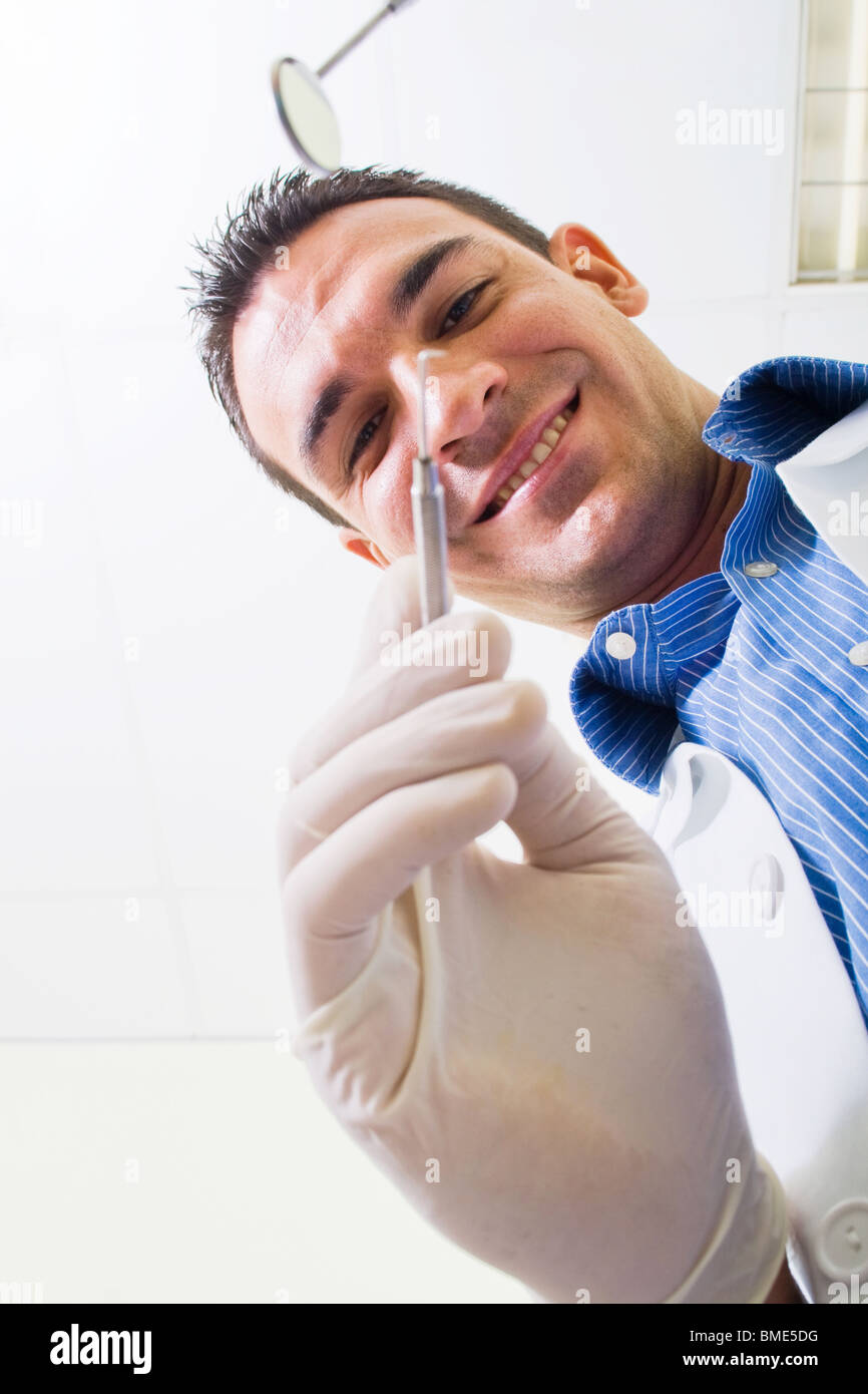 männliche Zahnarzt mit Tools schauen, Patientin Blick Engel Stockfoto