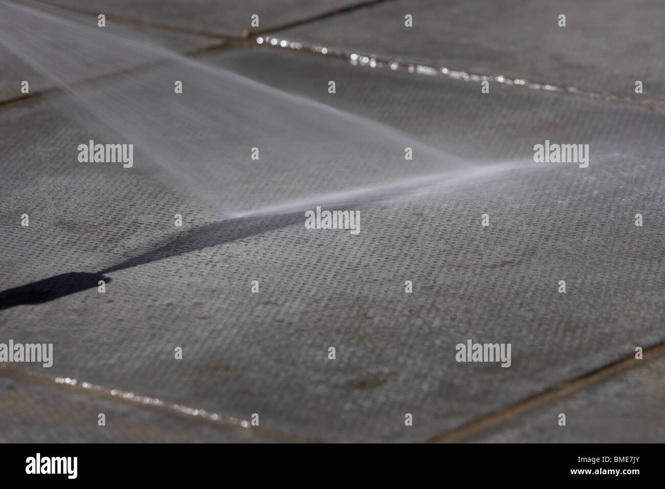 macht eine Betonplatte Schlauch gefliest Gartenterrasse im Vereinigten Königreich Stockfoto