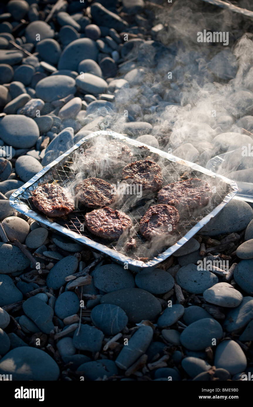 kochen Rindfleisch Burger auf eine billige Einweg-Grill am Strand, UK Stockfoto