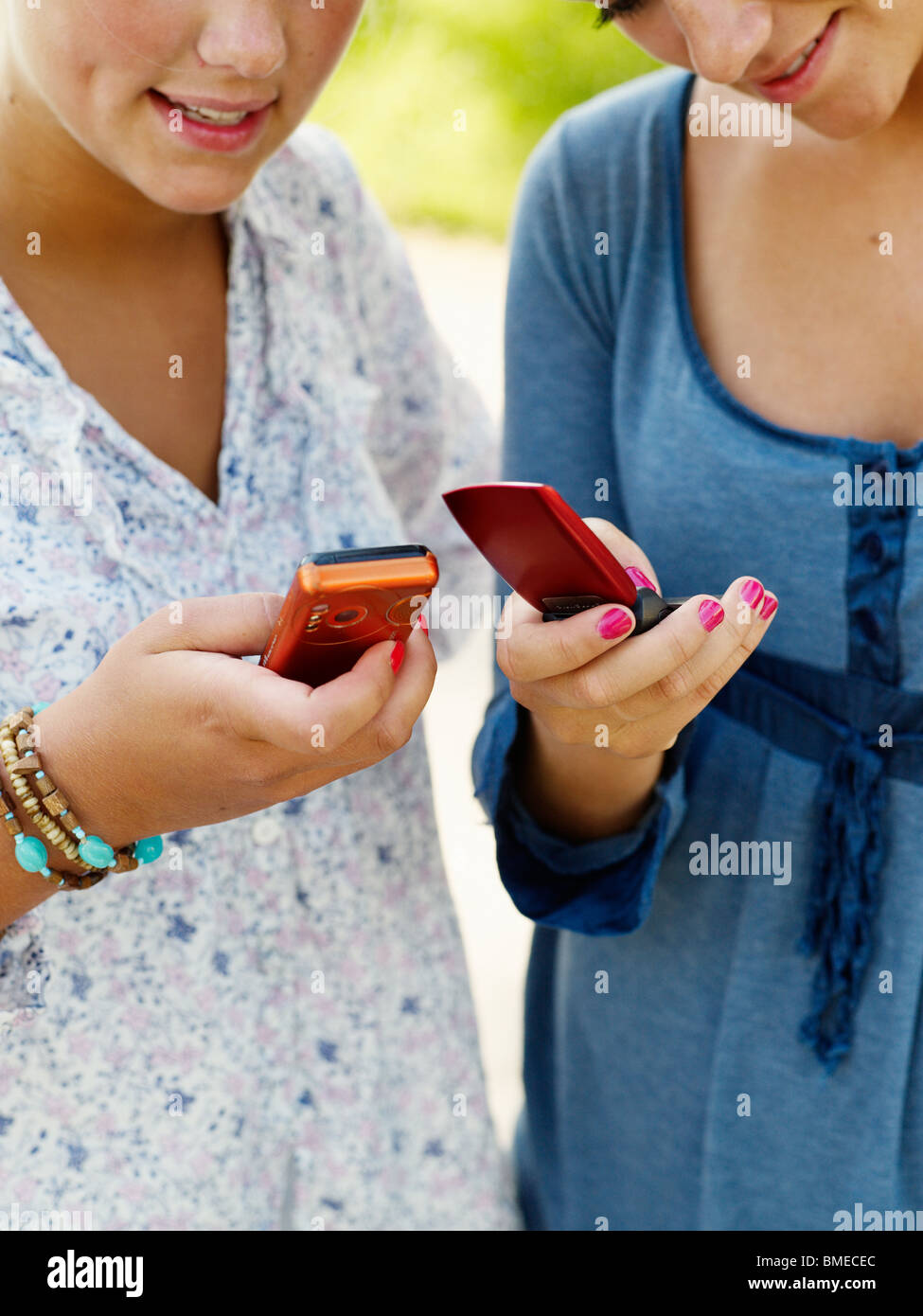 Junge Frauen halten Handys Stockfoto