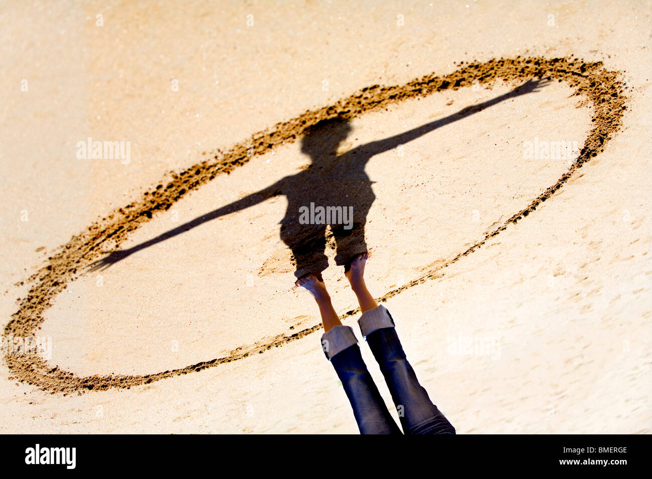 Schatten Vitruvian Man herausfinden auf sand Stockfoto